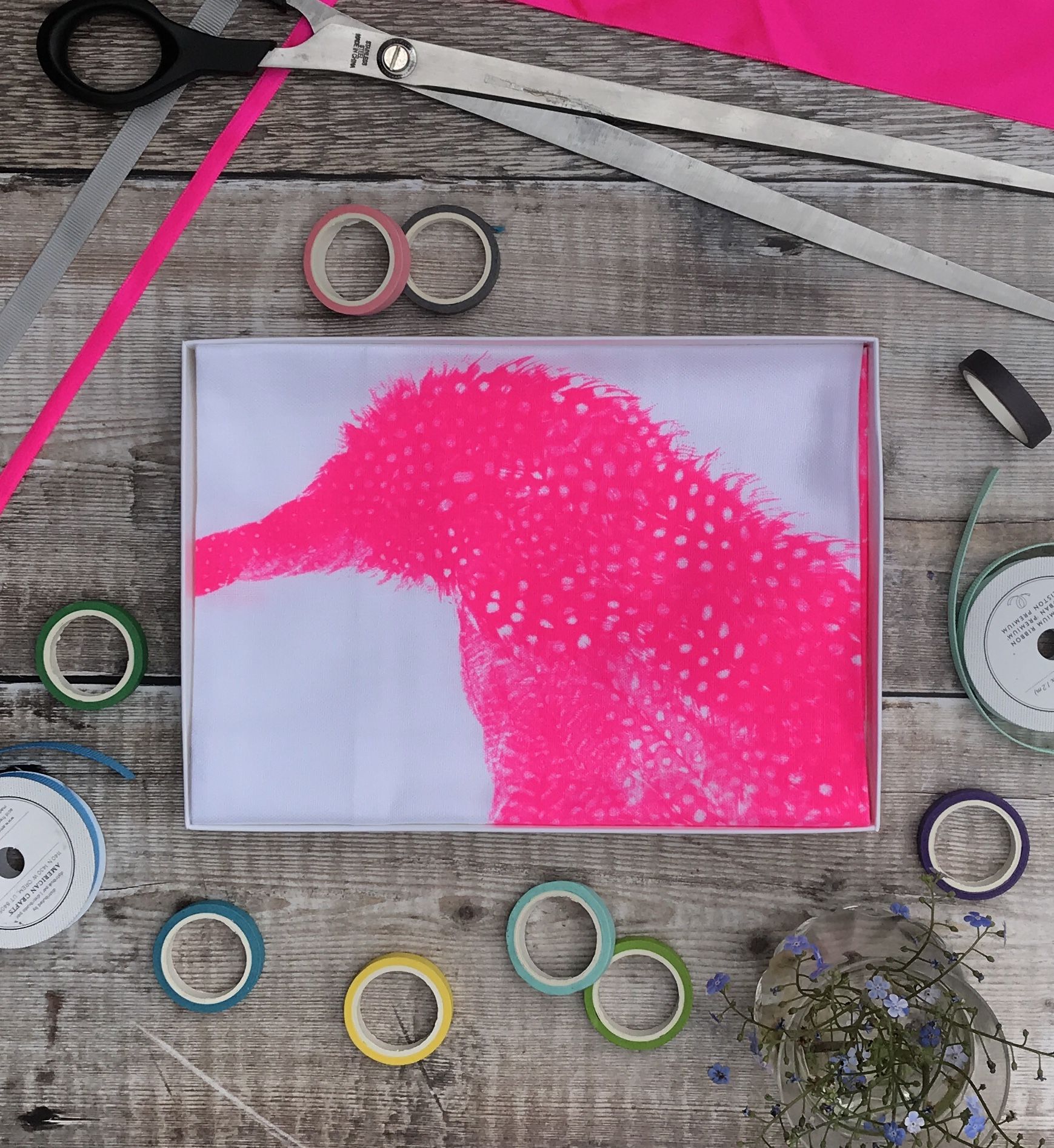 tea towel folded in an open box fluoro pink penguin