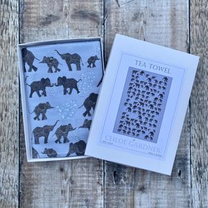 A GIFT BOXED TEA TOWEL - LOTS OF ELEPHANTS ON GREY