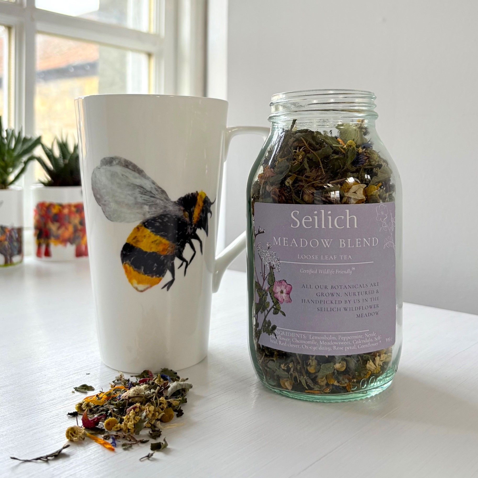 Bee latte mug and Seilich tea in windowsill by chloe gardner